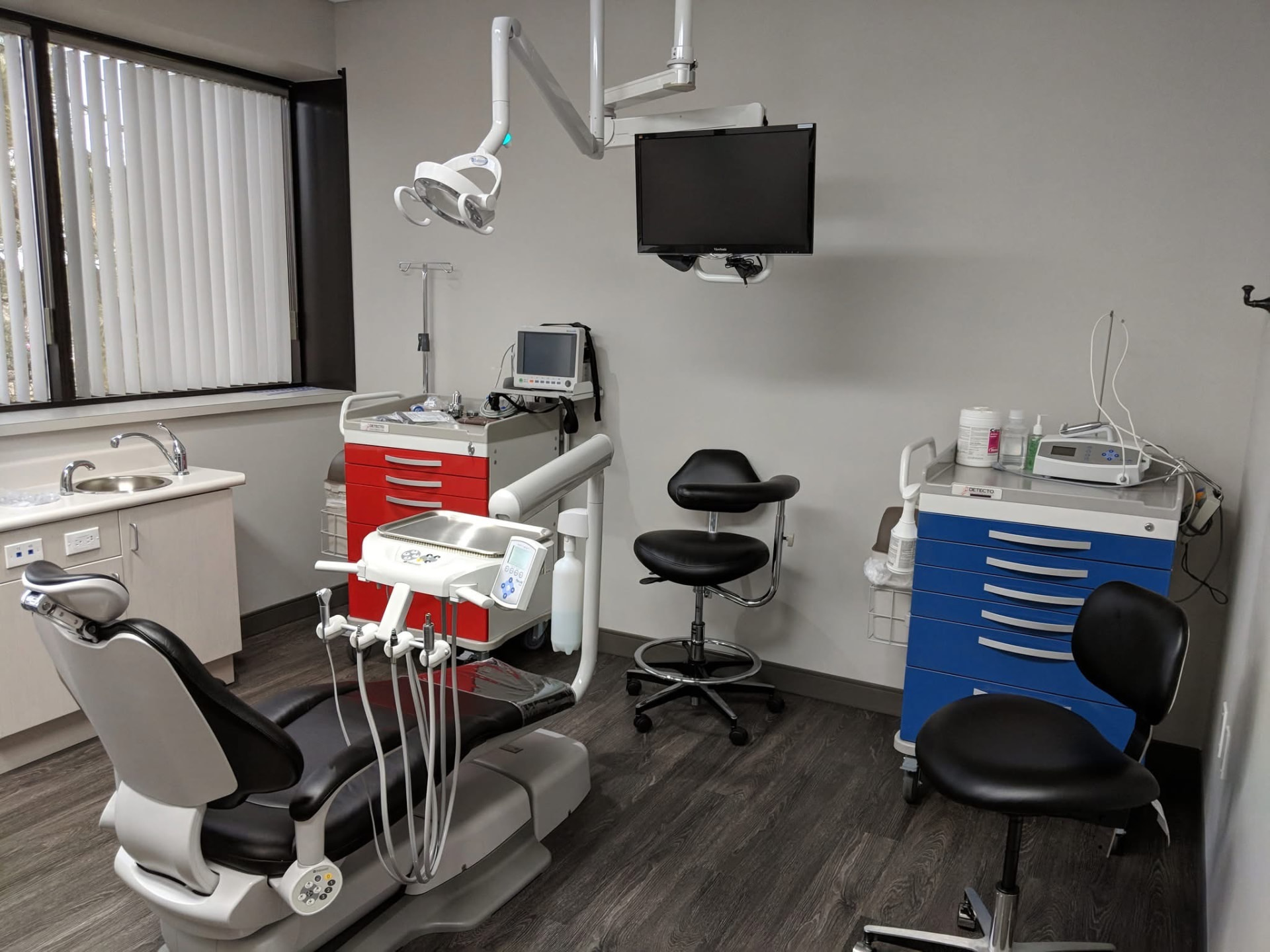 Dental treatment room with chair, lights, and equipment